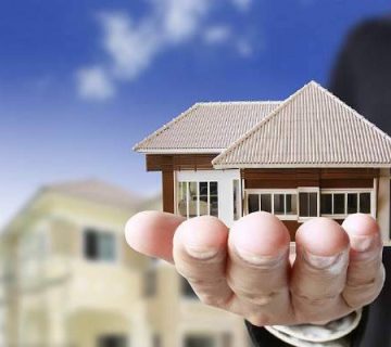 در دست داشتن یک ماکت چوبی خانه توسط یک مرد