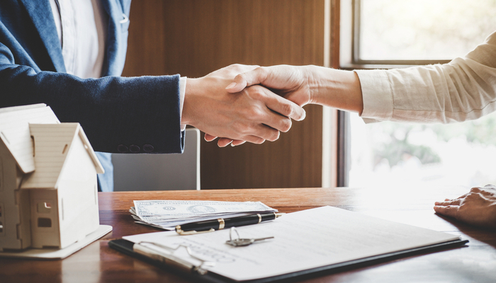 دو شخص در حال دست دادن بهم سر بستن قرار داد املاک