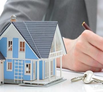 یک شخص در حال امضا جهت فروش ملک اجاره ای در کنار ماکت خانه