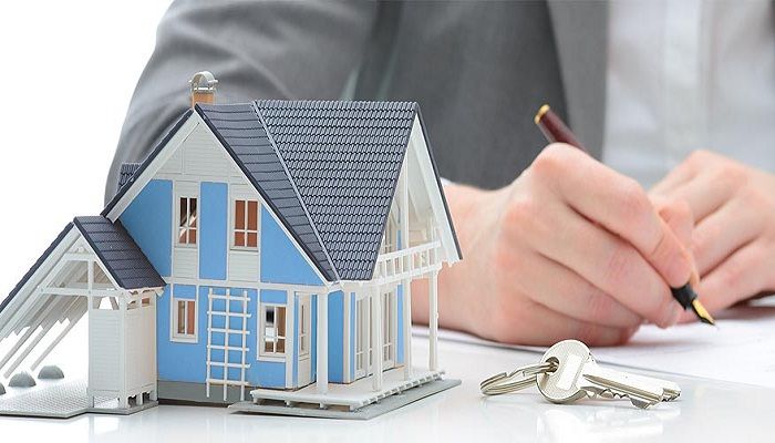 یک شخص در حال امضا جهت فروش ملک اجاره ای در کنار ماکت خانه
