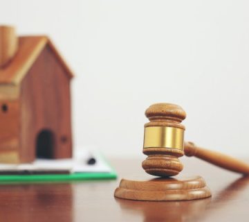 یک ماکت خانه در کنار چکش عدالت