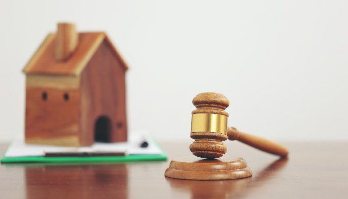 یک ماکت خانه در کنار چکش عدالت