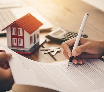 یک شخص در حال امضای قرار داد اجاره ملک مشاع است.