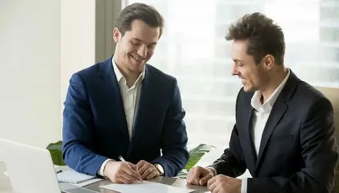 دو مرد با لباس کت و شلوار در حال بررسی نمونه دادرخواست برای اثبات شرکای ملک