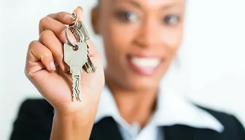 یک خانم که در دست خود یک کلید دارد.