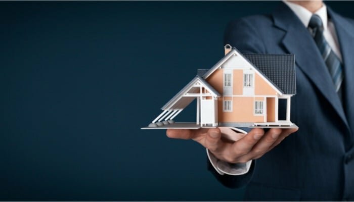 یک شخص که در دست خود یک ماکت ویلا دارد